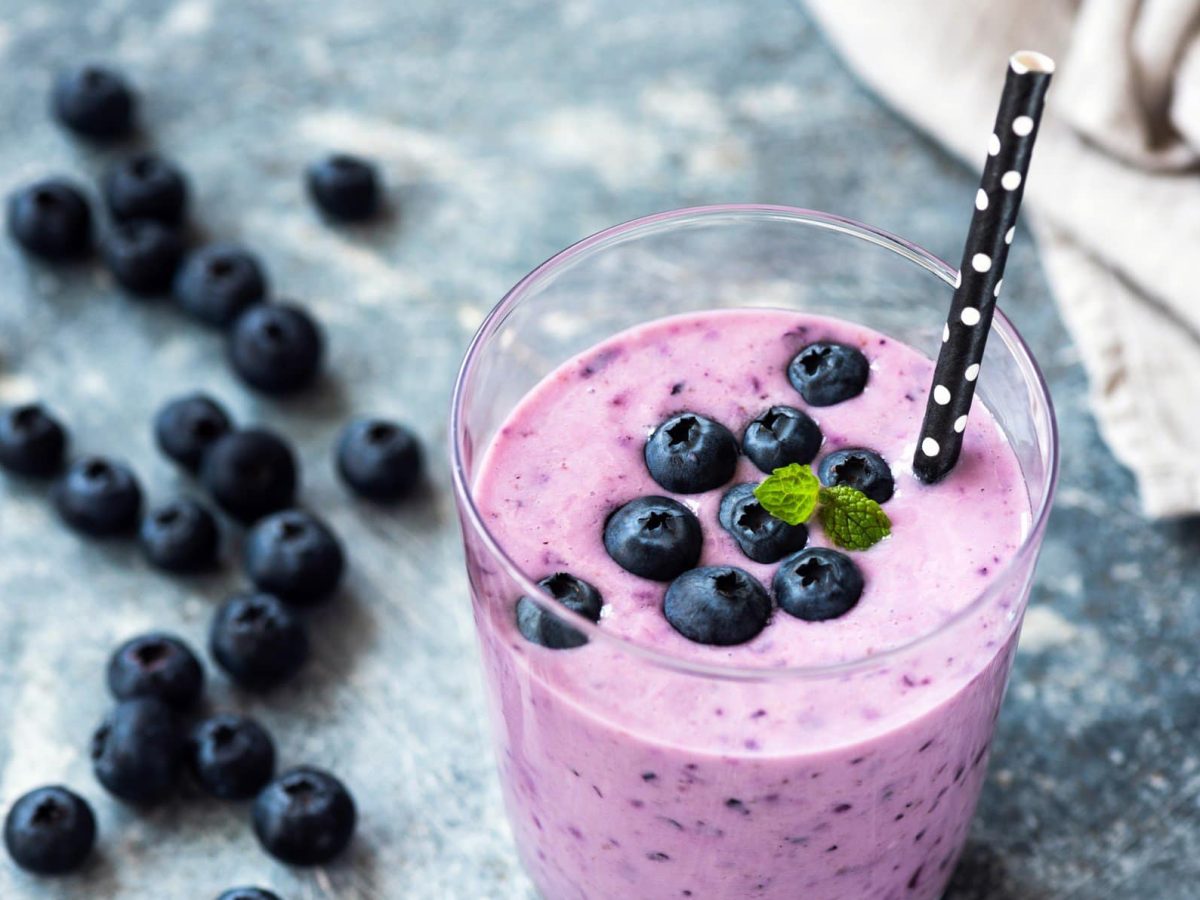 Blaubeer-Joghurt-Smoothie im Glas mit Strohhalm