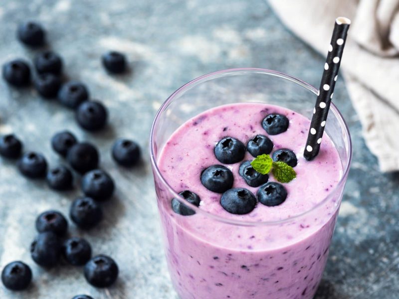 Blaubeer-Joghurt-Smoothie im Glas mit Strohhalm