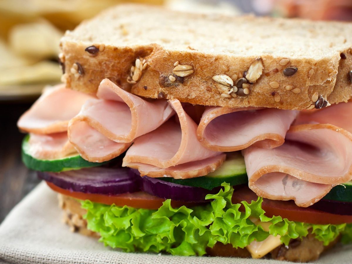 Puten-Sandwich mit knackigem Gemüse auf Körnerbrot mit Tomate, Gurke, Zwiebeln und Salat