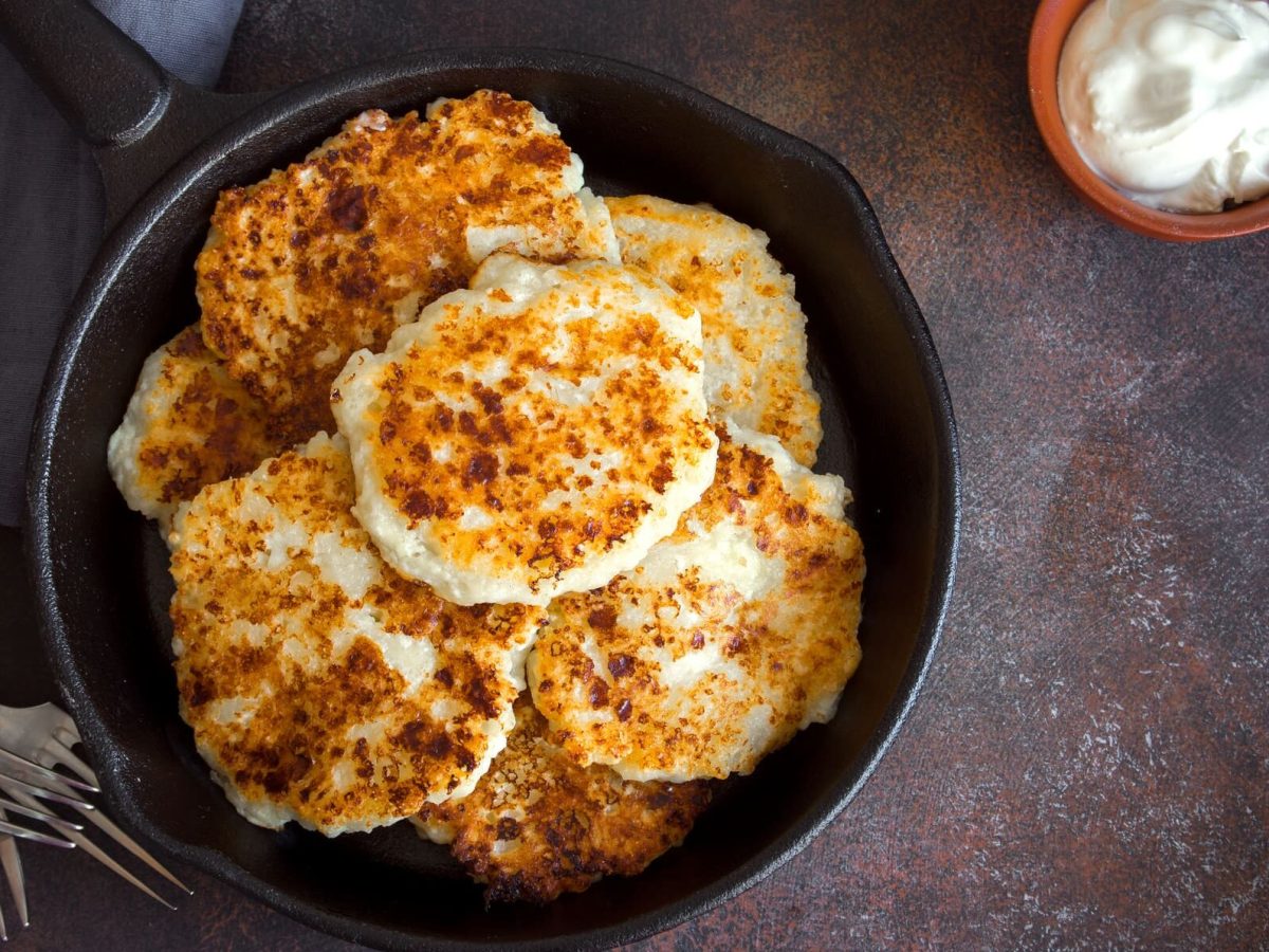 Vegetarisches Kohlrabi-Schnitzel mit selbstgemachtem Dip in Pfanne, daneben Schüssel mit Dip