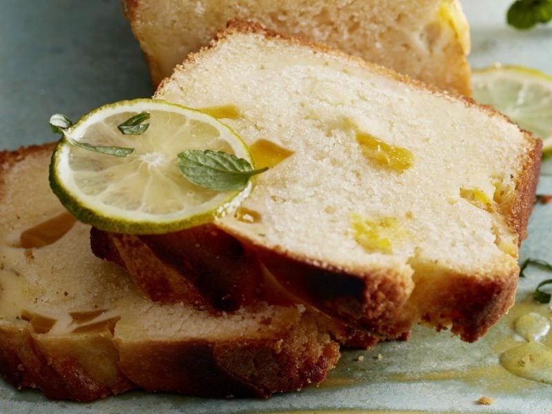 Mango-Schmand-Kastenkuchen mit Limette garniert auf blauer Platte