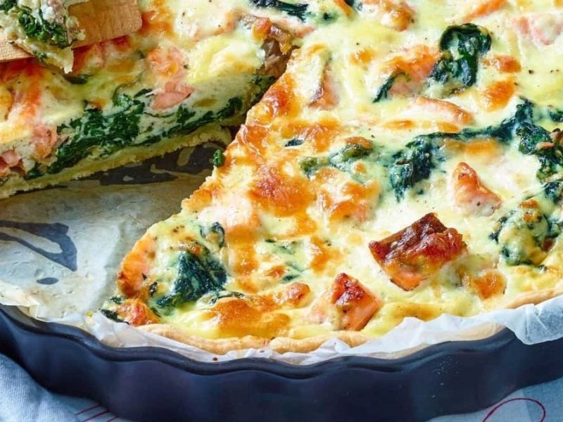 Eine Lachs-Spinat-Quiche steht auf einem Tisch.