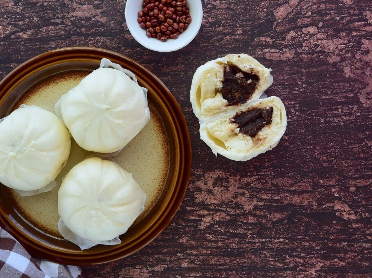 Anman, japanische Brötchen, die mit süßer Atzukibohnenpaste gefüllt und gedämpft werden, auf dunklem Hintergrund von oben