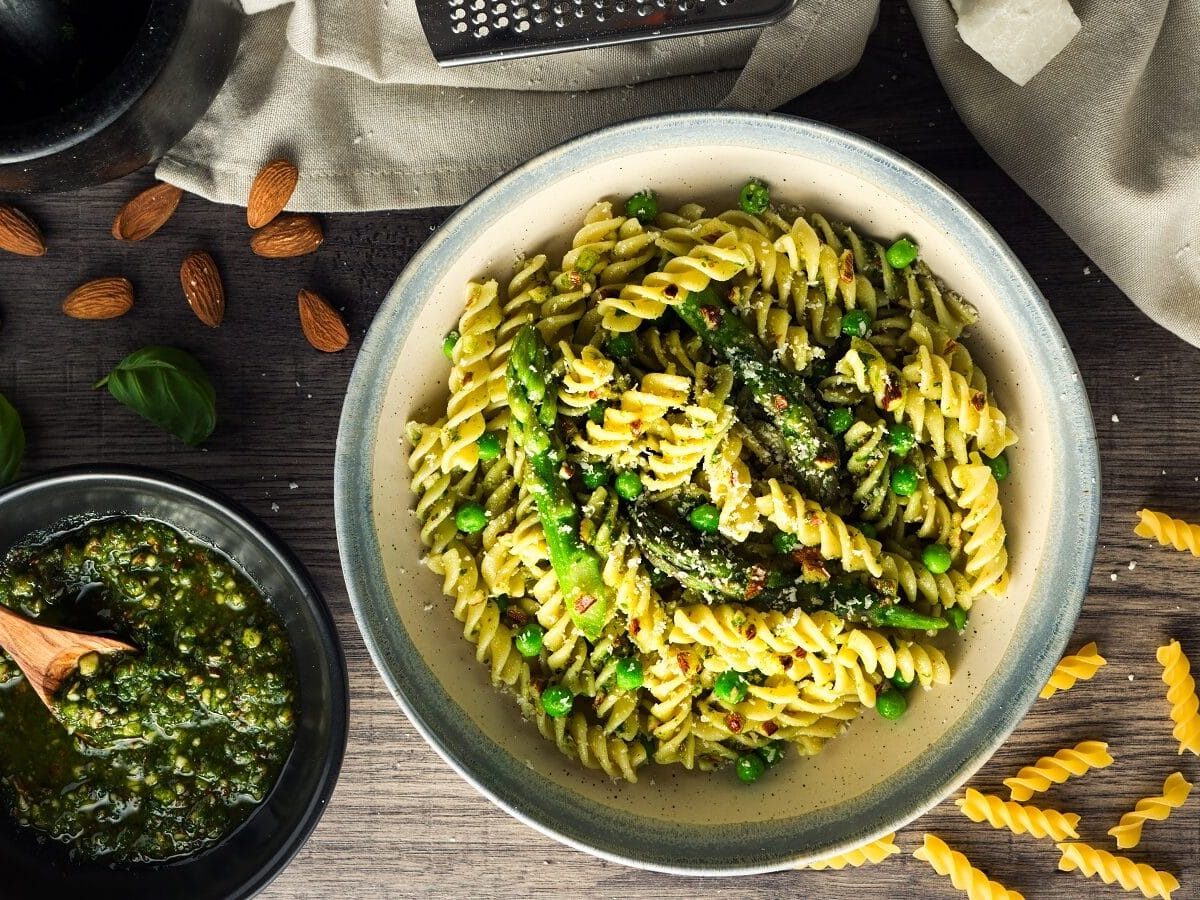 Spirelli-Pasta mit Pesto und grünem Spargel und Erbsen, mit geriebenem Parmesan garniert, von oben