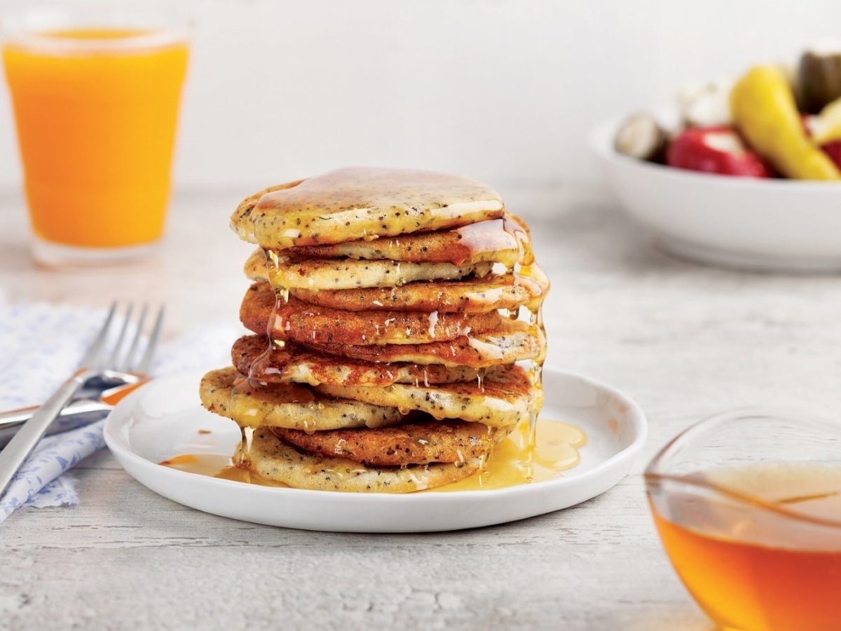 Pancakes mit Chiasamen und Agavensirup auf einem Teller.