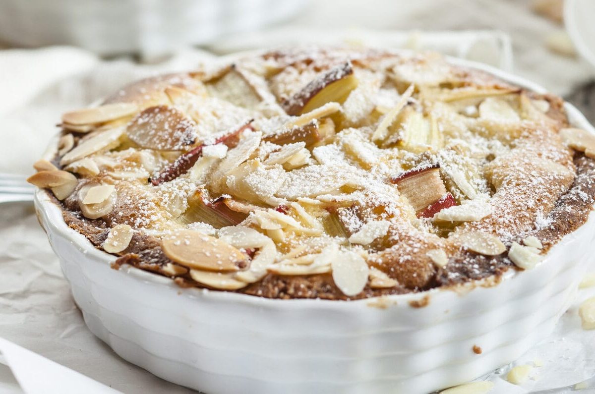 Ein Rhabarberkuchen mit Eierlikör und Mandeln in einer weißen Kuchenform