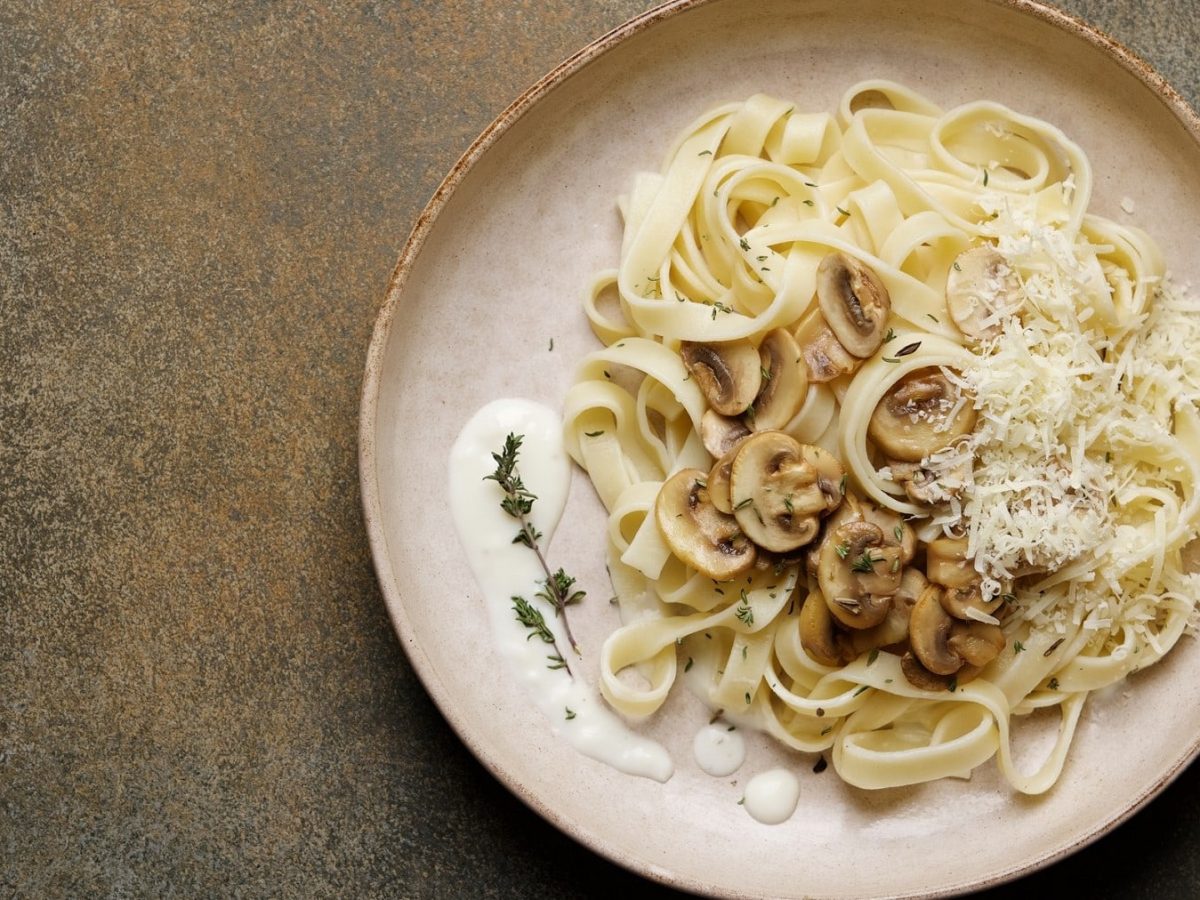 Ein Teller mit Tagliatelle mit Pilzen und würzigem Parmesan