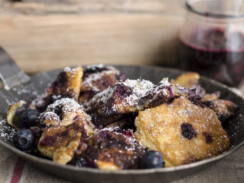 Kaiserschmarrn mit Blaubeeren in einer kleinen Pfanne.