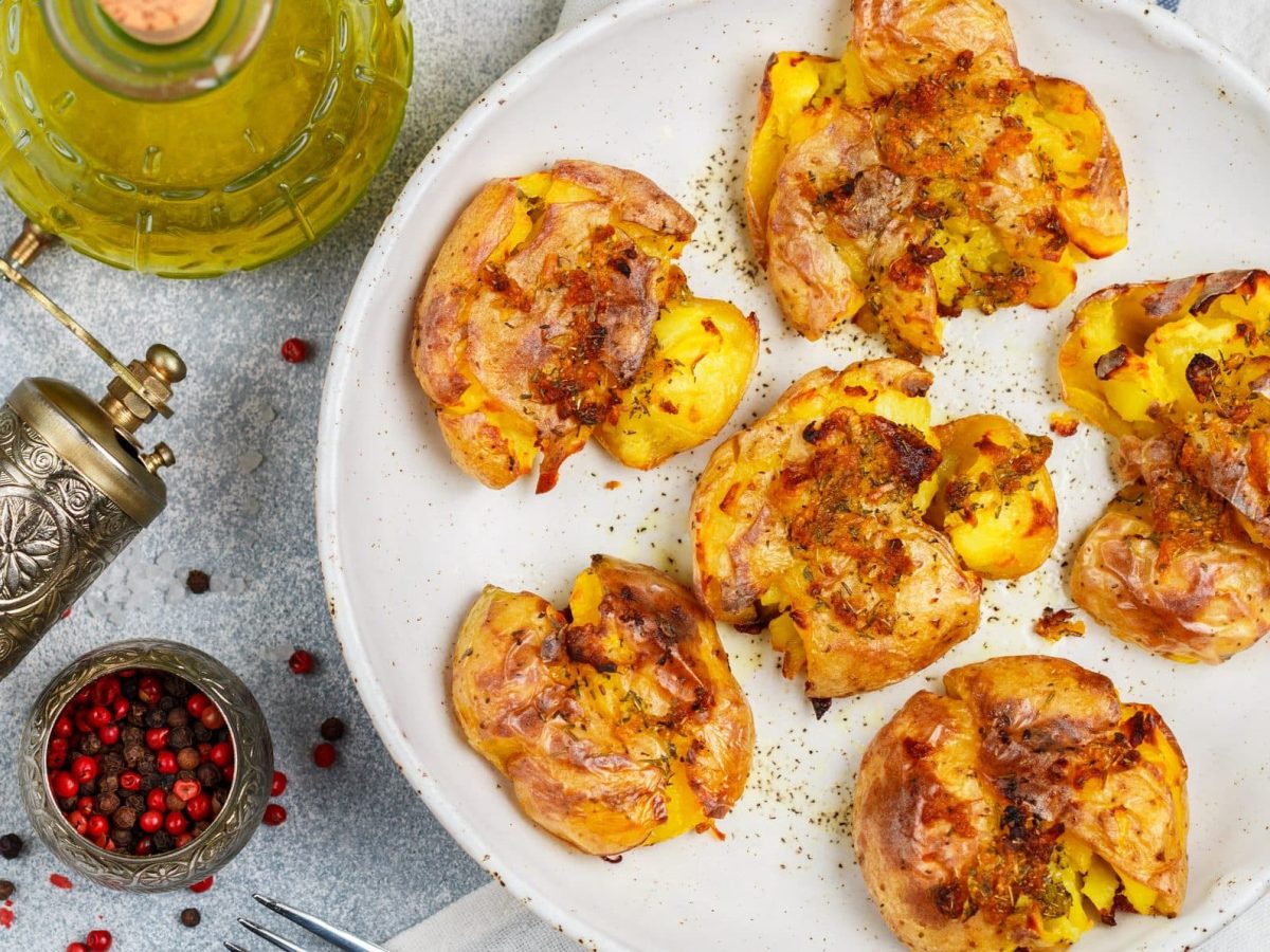 Smashed Potatoes auf weißem Teller