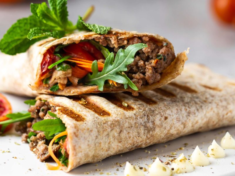 Zwei Wraps mit Hackfleisch, Rucola. Tomaten und Möhren.