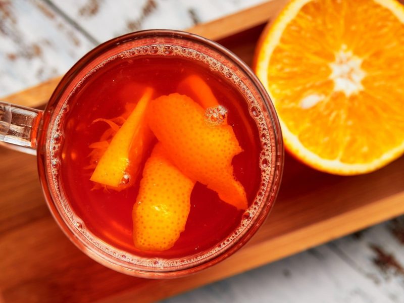 Hot Aperol in durchsichtigen Gläsern auf Holztablett