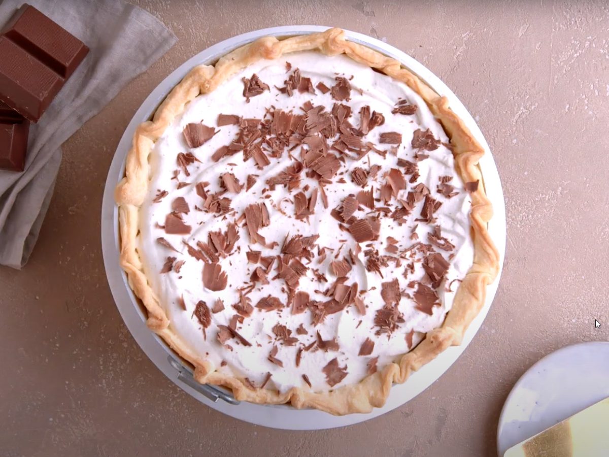 Französischer Seidenkuchen mit Schokocreme und Sahne auf weißem Teller.