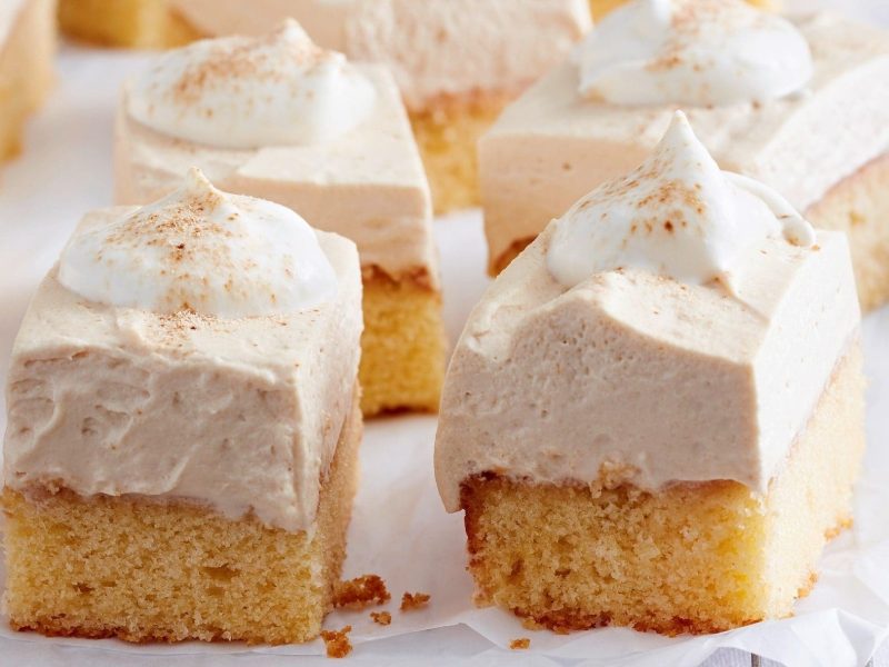 Unser Cappuccino-Creme-Kuchen liegt in Stücke geschnitten auf Backpapier aus.