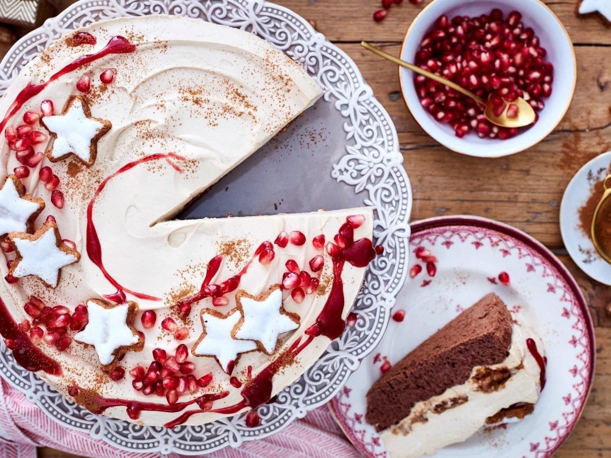 Ein Stück von unserer Zimtstern-Tiramisu-Torte liegt auf dem Teller, die restliche Torte auf der Tortenplatte.