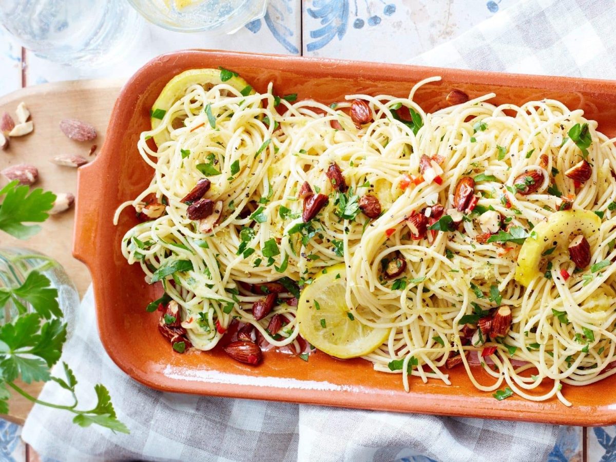 Die Zitronen-Mandel-Spaghetti angerichtet in einer länglichen Auflaufform.