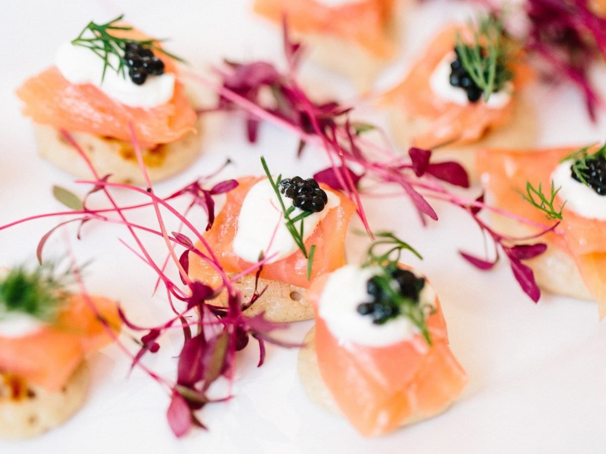 Canapes mit Lachs und Kaviar auf weißem Teller