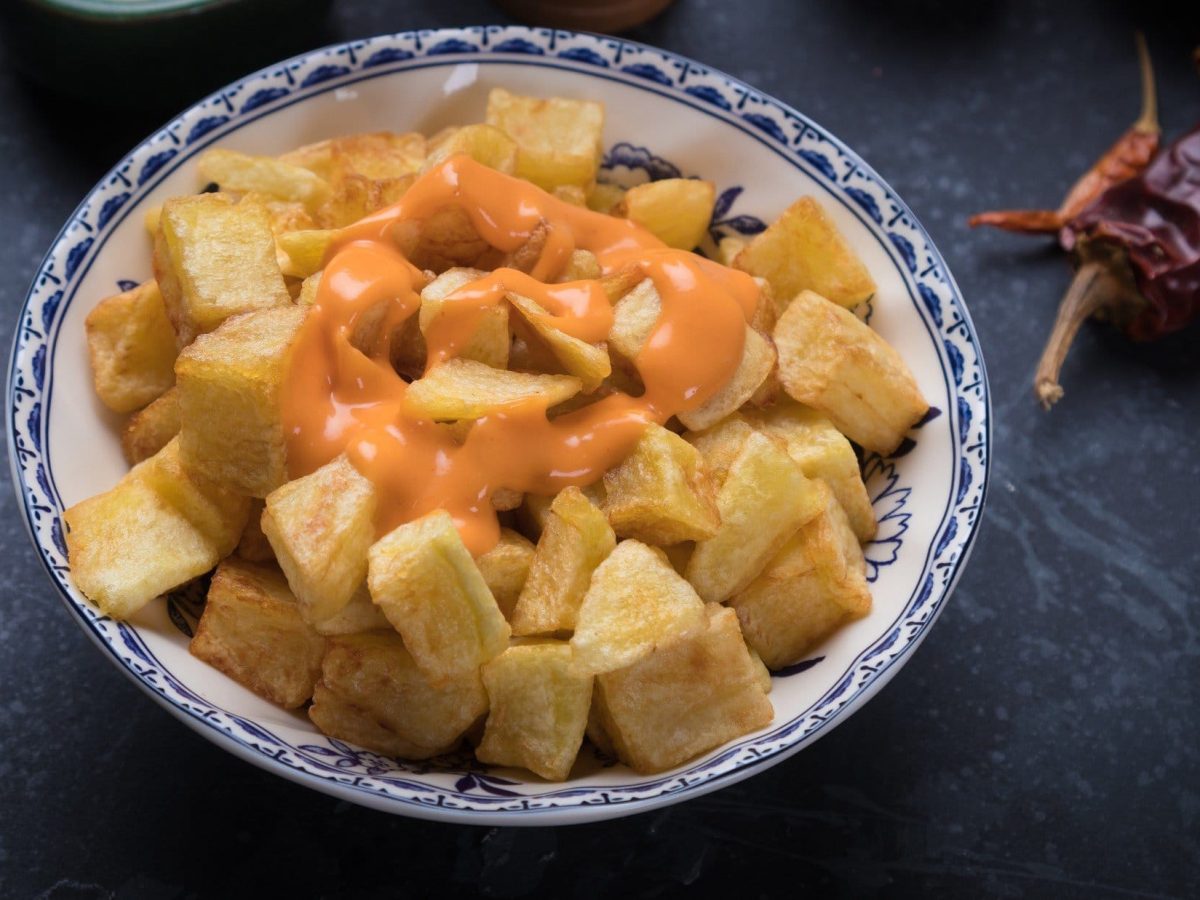 Patatas bravas mit Dip auf dunklem Untergrund