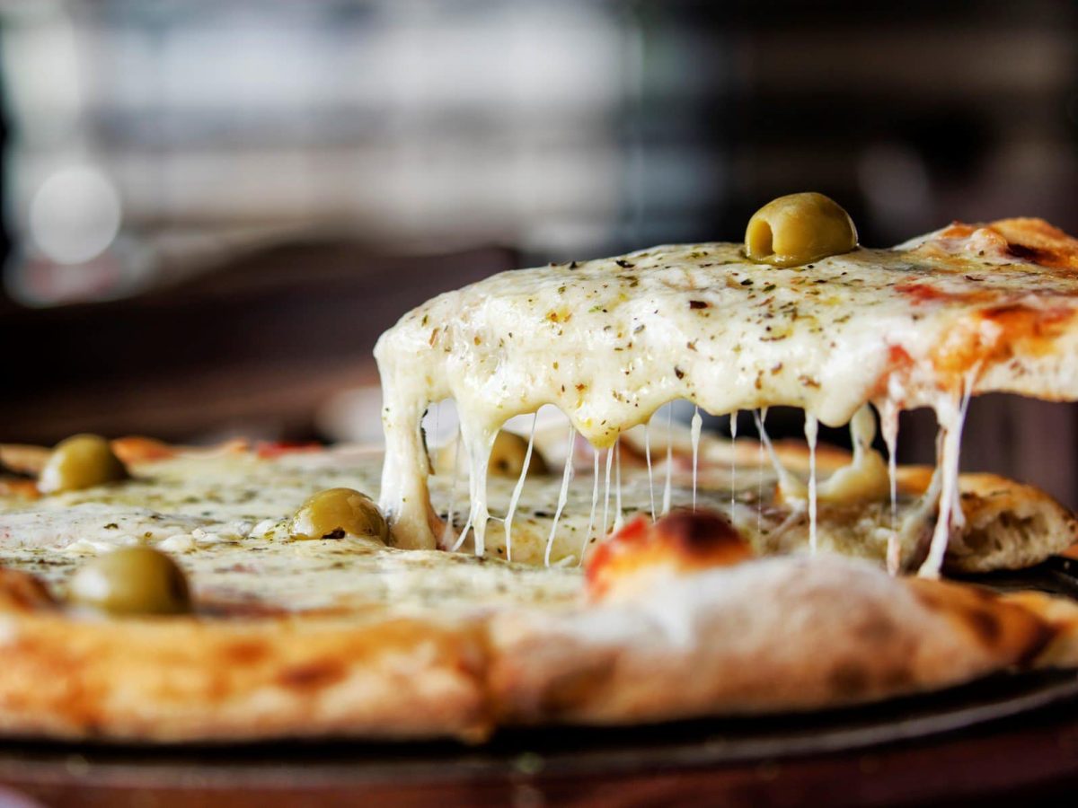 Pizza mit geschmolzenem Käse, Oliven und Pizzagewürz