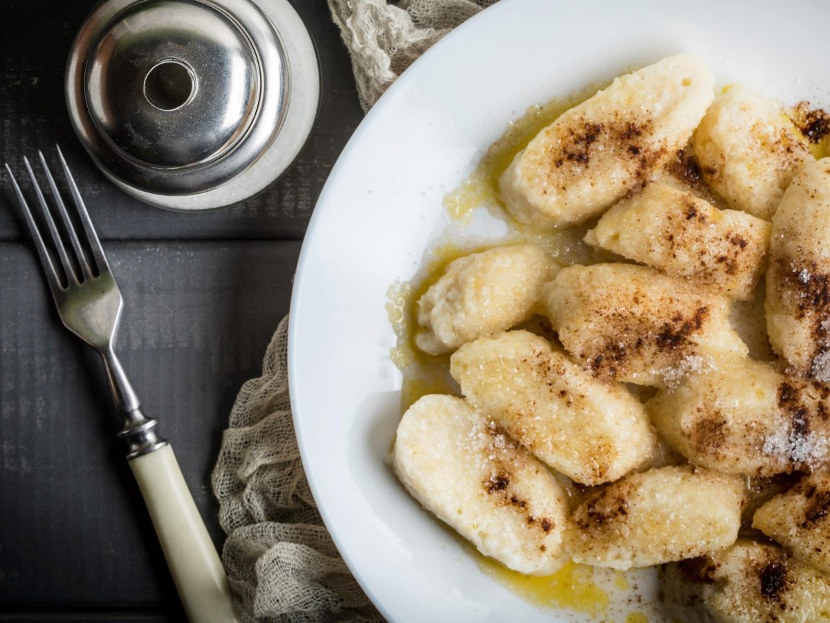 Polnische Faulenzer: Süße Quarkspeise als kleine Quarkpierogi mit Zimt und Zucker bestäubt und Butter beträufelt