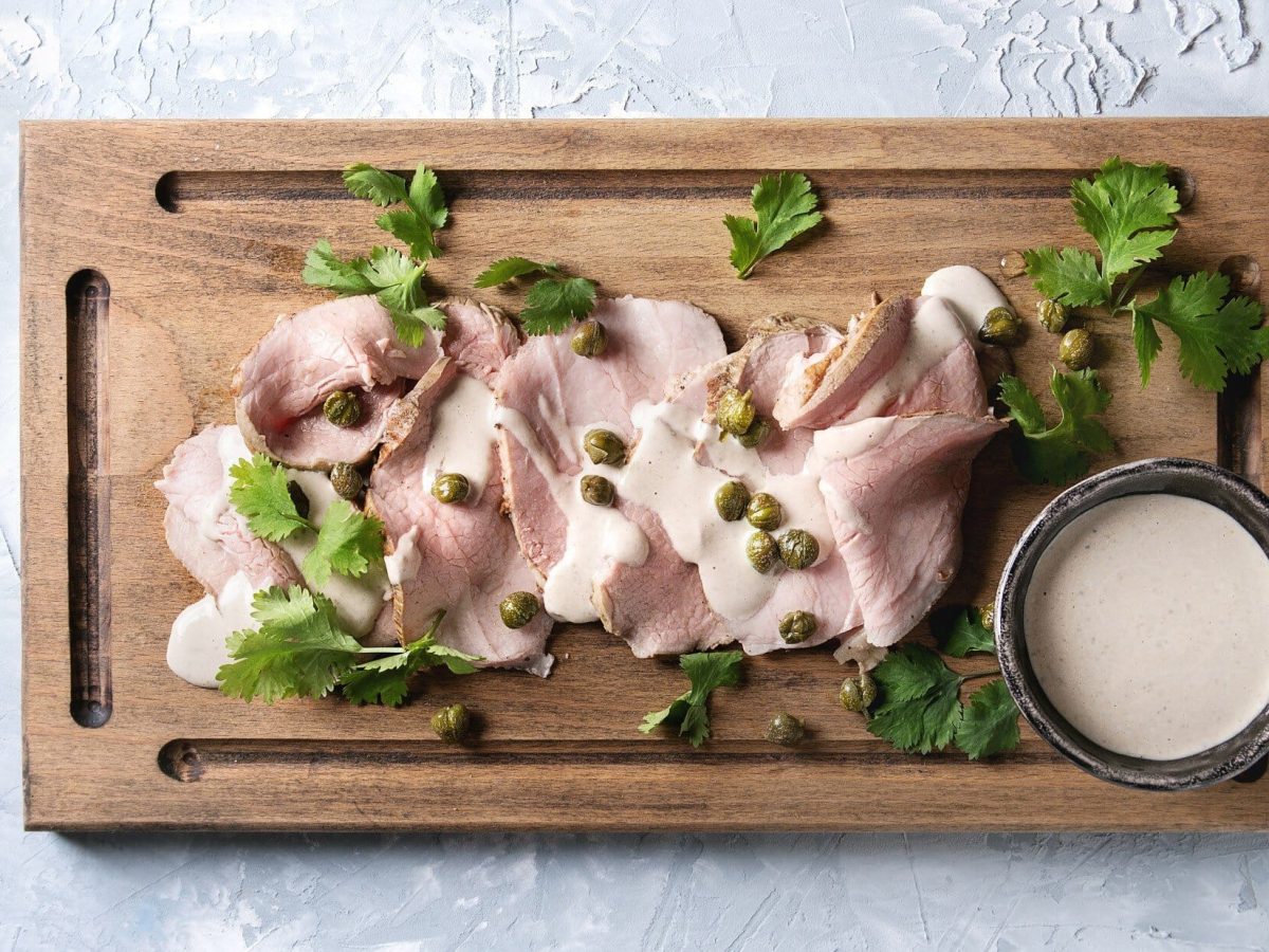 Vitello Tonnato auf Holbrett mit Kräutern