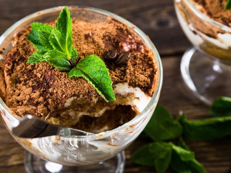 In kleinen Gläsern angerichtetes Tiramisu mit Bratäpfeln und Mascarpone, garniert mit frischem Pfefferminz