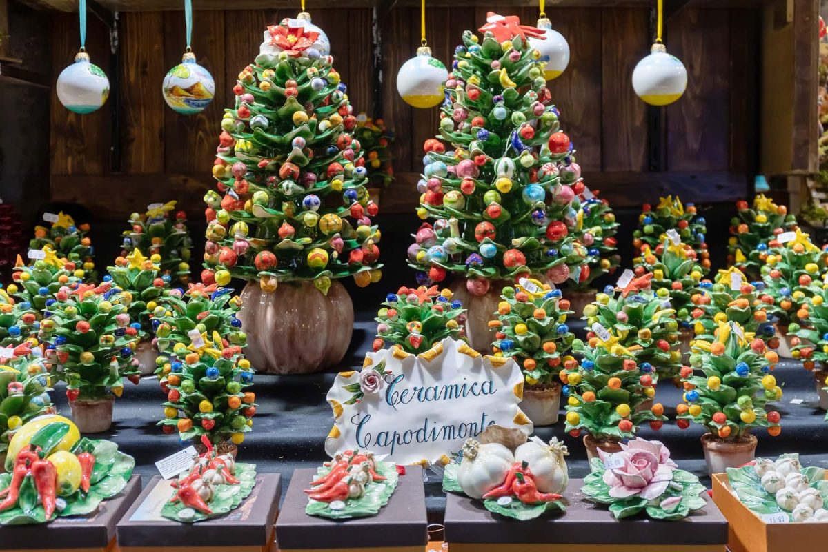 Frontalsicht: In einem Schaufenster stehen festlich geschmückte Weihnachtsbäume