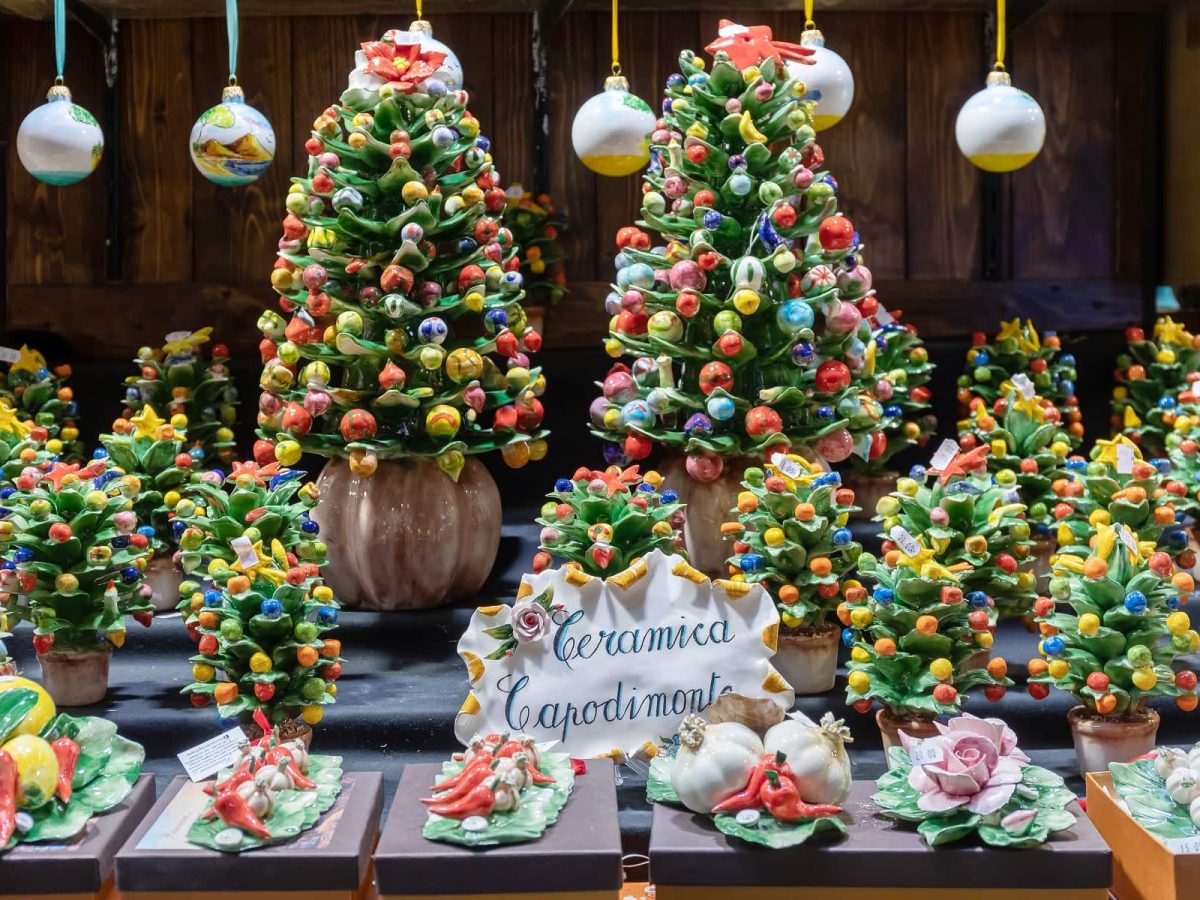 Frontalsicht: In einem Schaufenster stehen festlich geschmückte Weihnachtsbäume