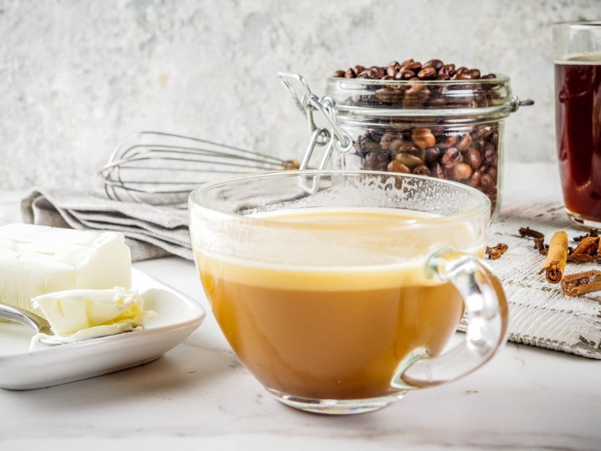 Bulletproof Coffee mit den Zutaten Kaffee und Butter in hellem Ambiente.