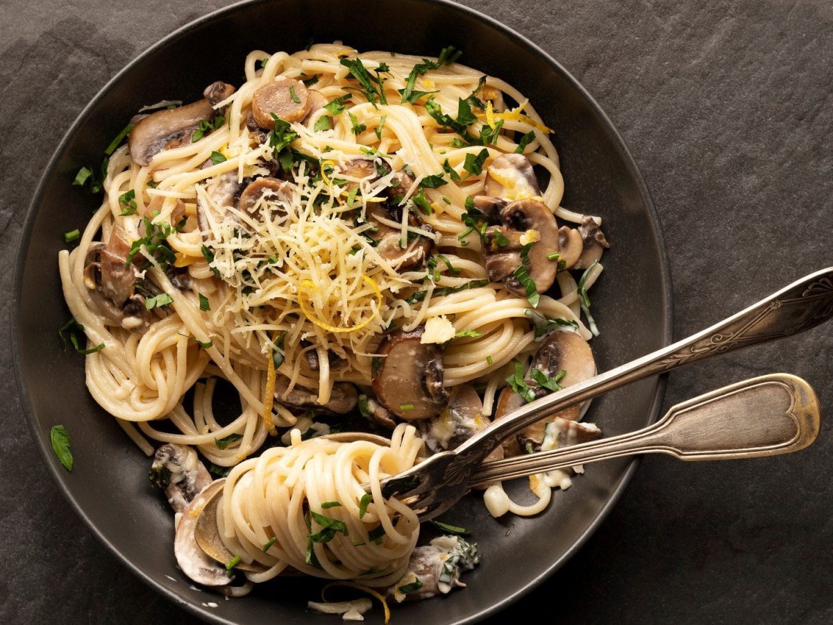 Spaghetti Carbonara mit Pilzen auf Schieferuntergrund.