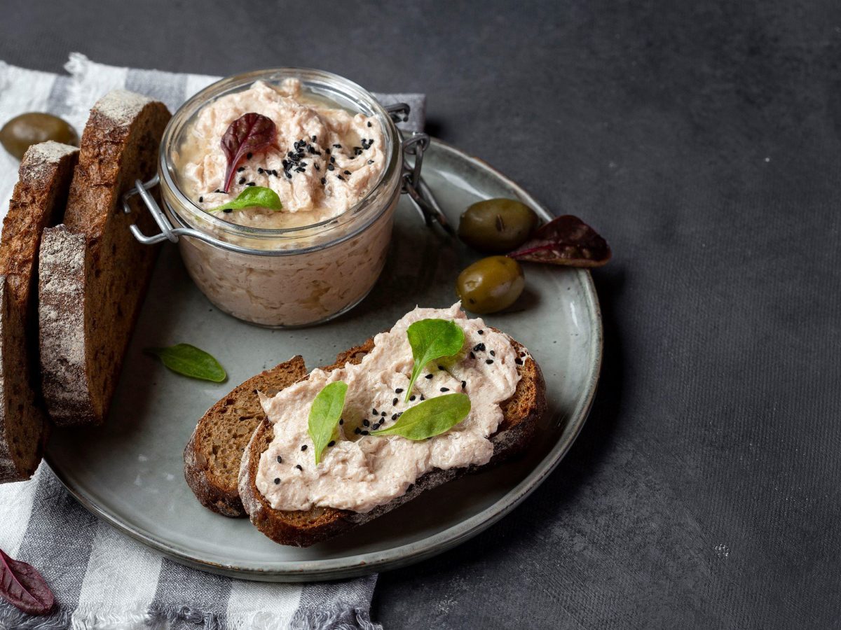 Brot mit Thunfischaufstrich auf dunklem Untergrund.