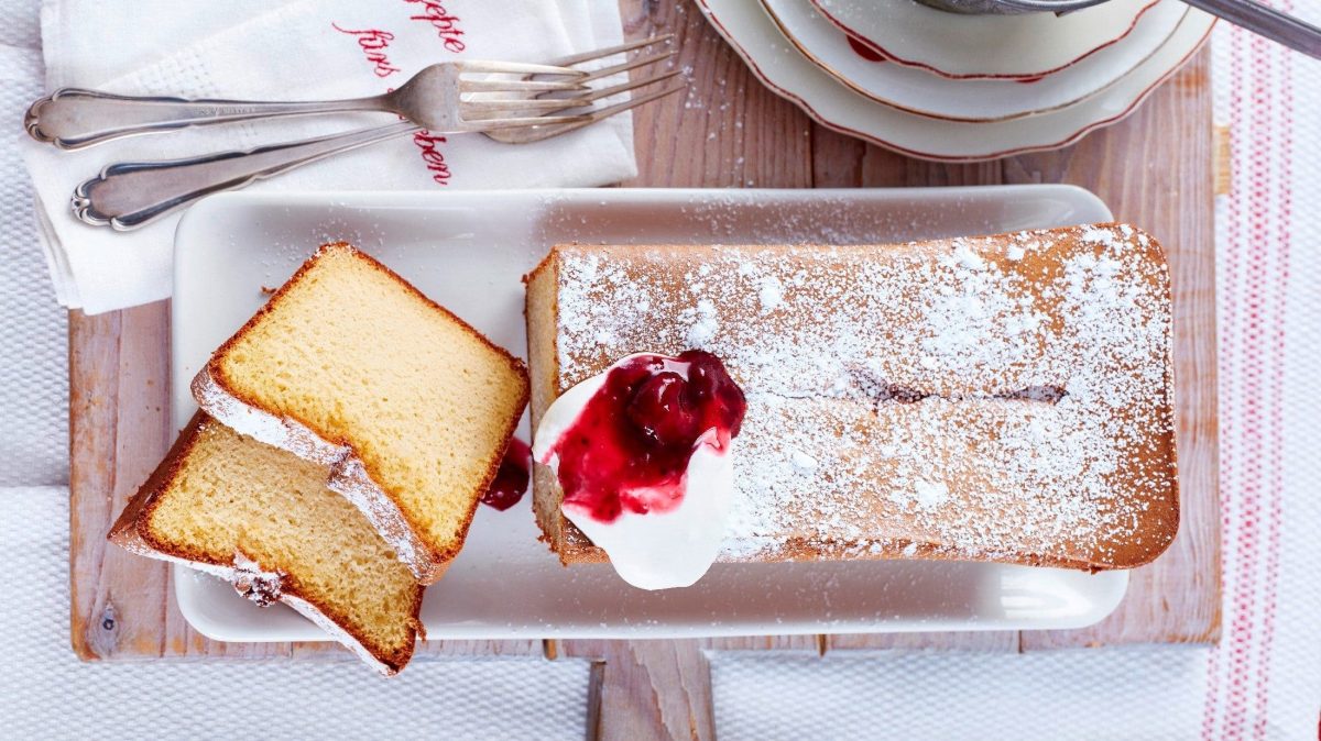 Unser 2-Zutaten-Marzipankuchen serviert auf einem länglichen Teller. Zwei Stücke davon sind bereits abgeschnitten.