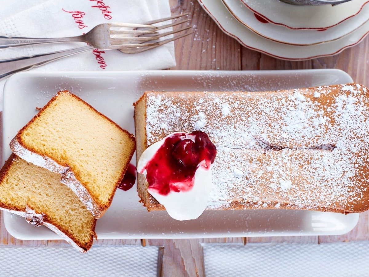 Unser 2-Zutaten-Marzipankuchen serviert auf einem länglichen Teller. Zwei Stücke davon sind bereits abgeschnitten.