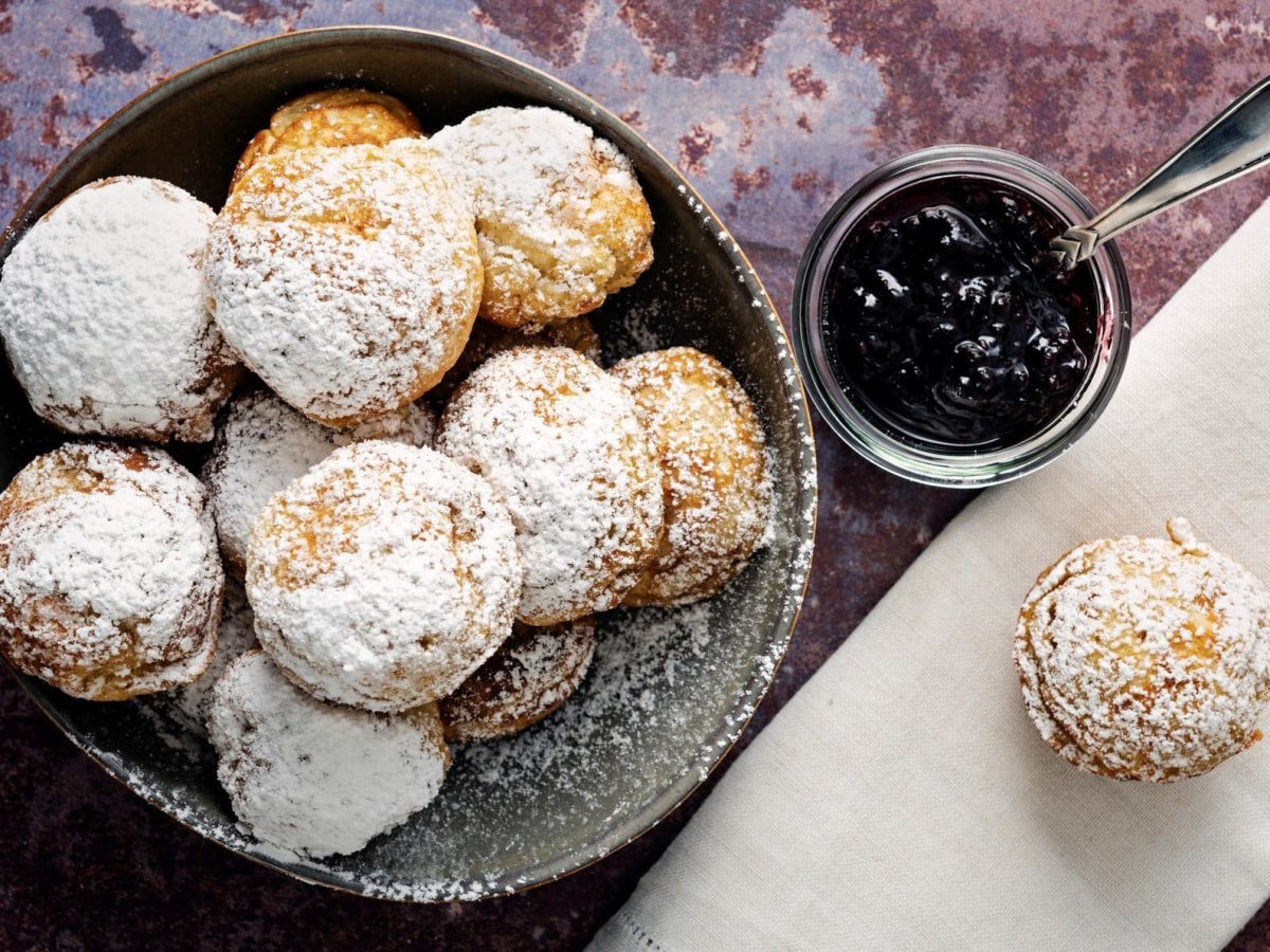 Aebleskiver mit Marmelade auf violettem Untergrund.