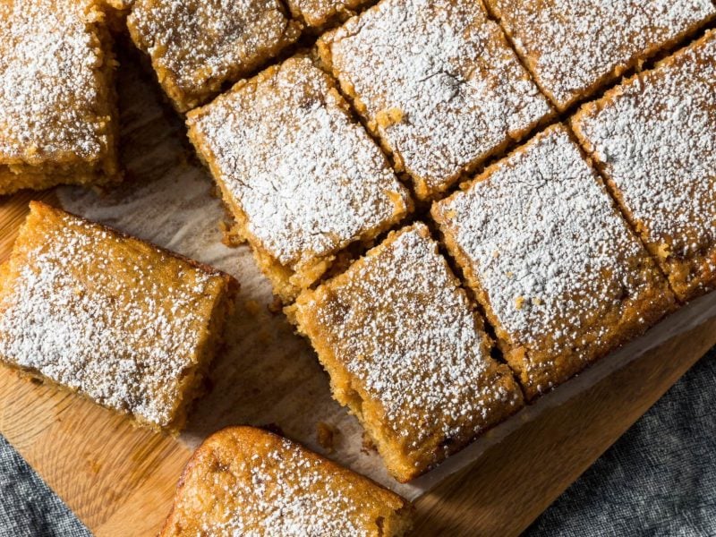 Apfelmuskuchen mit Puderzucker bestäubt auf Holzbrett