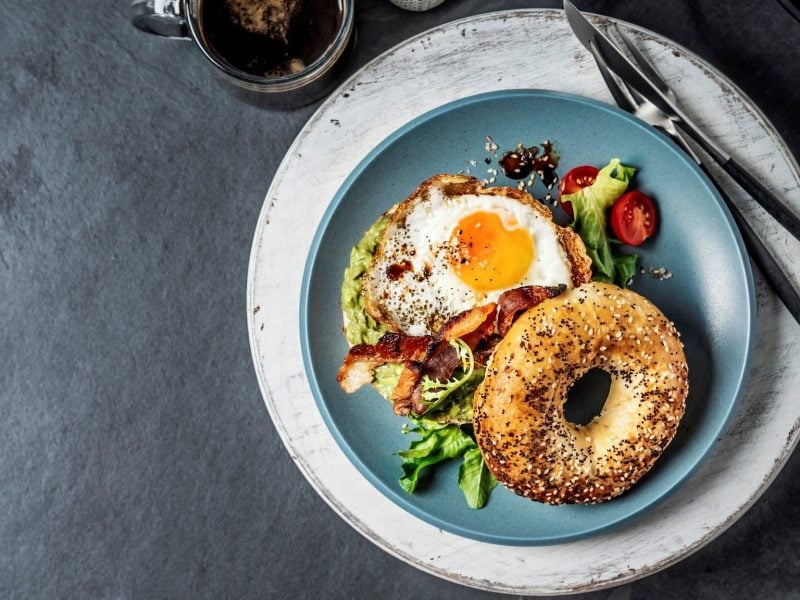 Bagel mit Spiegelei auf Teller serviert.