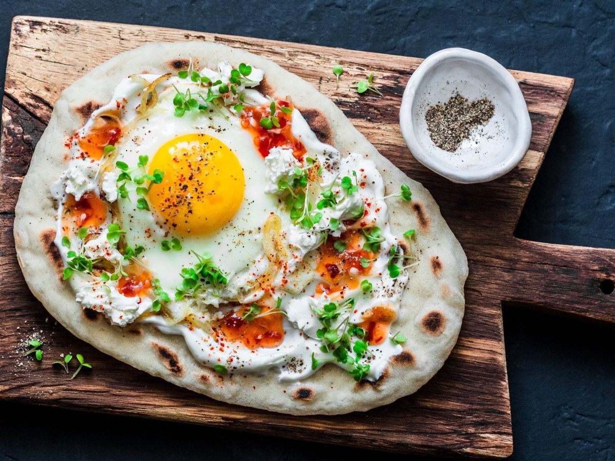 Unser Frühstücks-Naan angerichtet auf einem rustikalen Holzbrett.