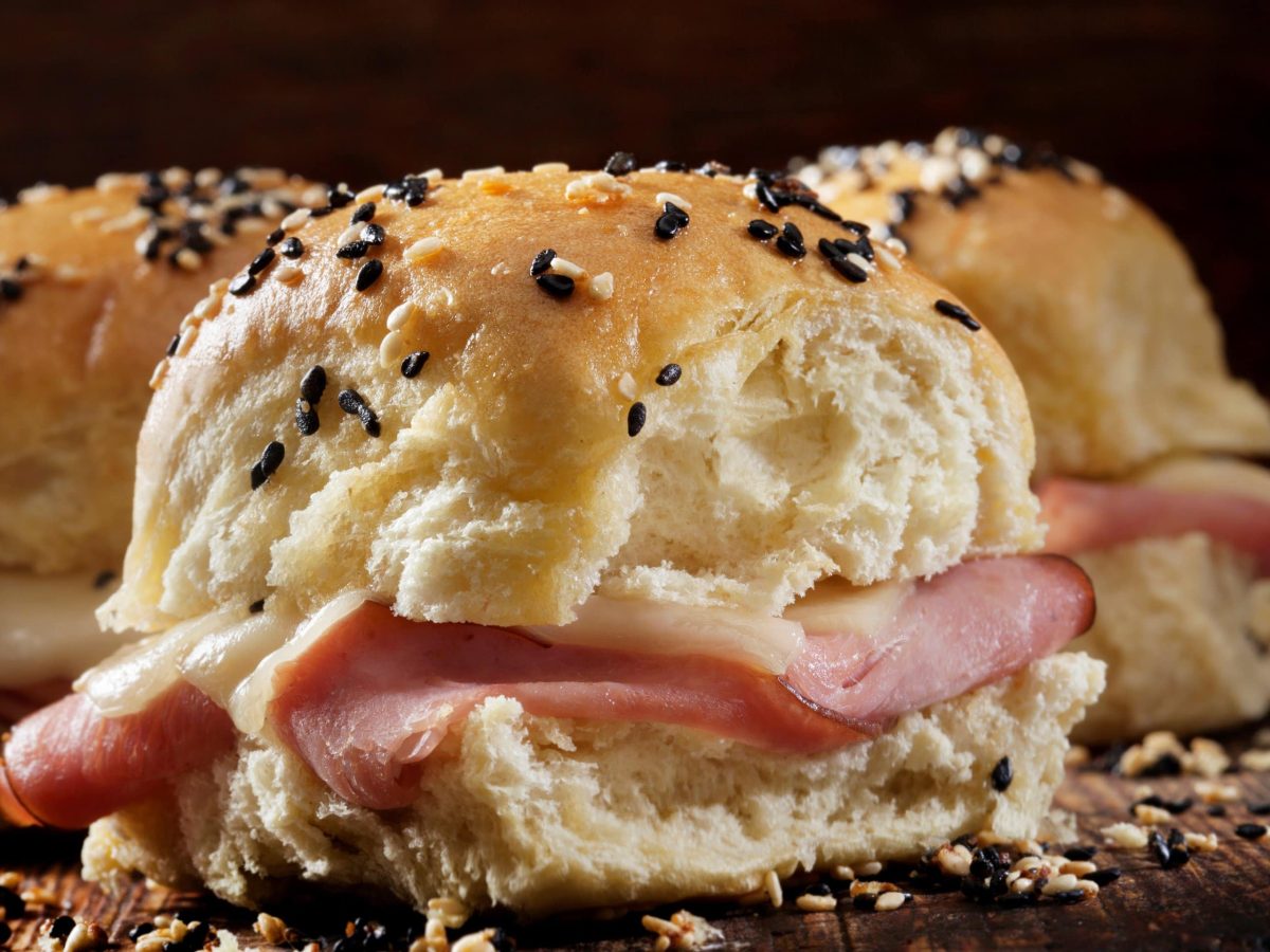 seitliche Nahaufnahme von den Käse-Schinken-Sliders mit schwarzem Hintergrund