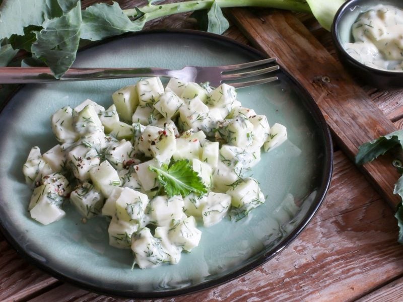 Auf einem Teller liegt ein angerichteter Kohlrabi-Salat mit einem Joghurt-Dressing