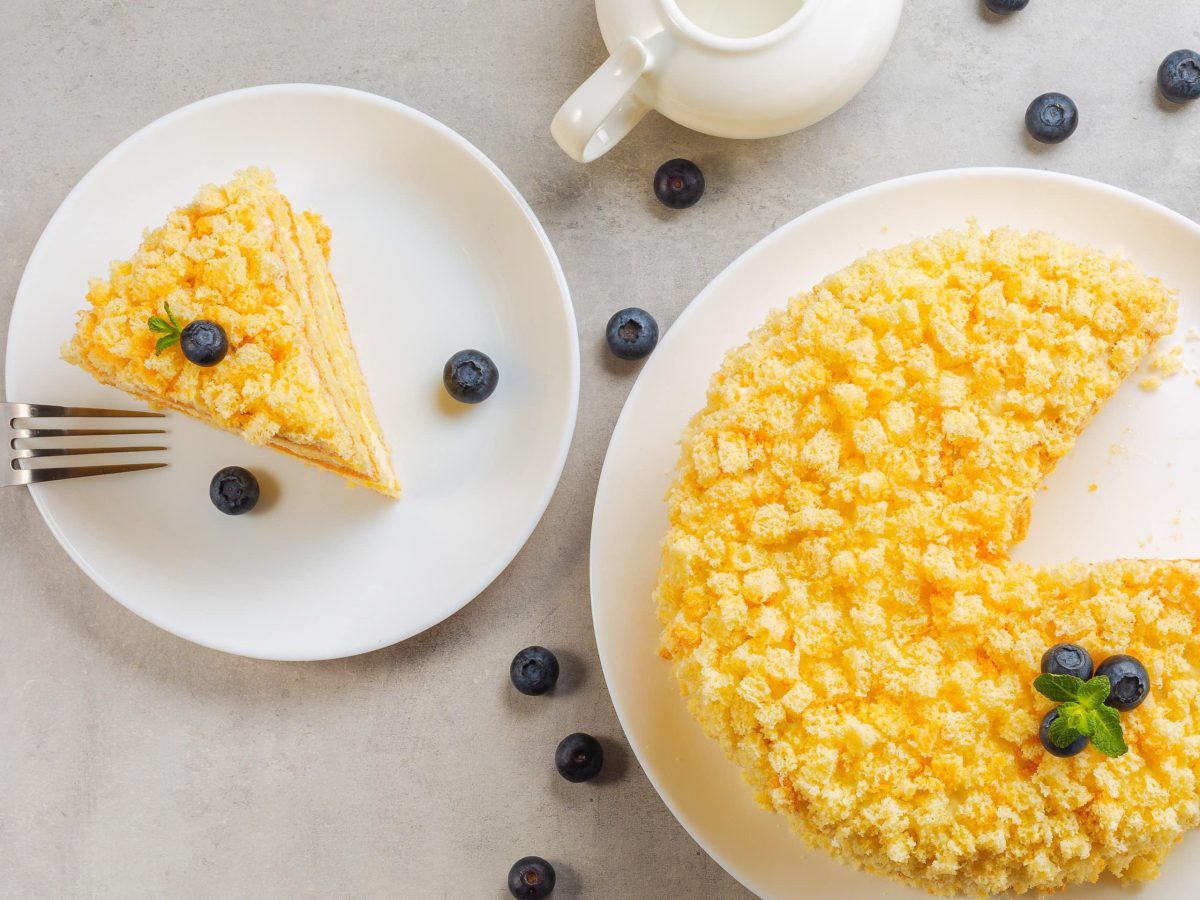 Mimosa Torte von oben mit Blaubeeren auf grauem Tisch.