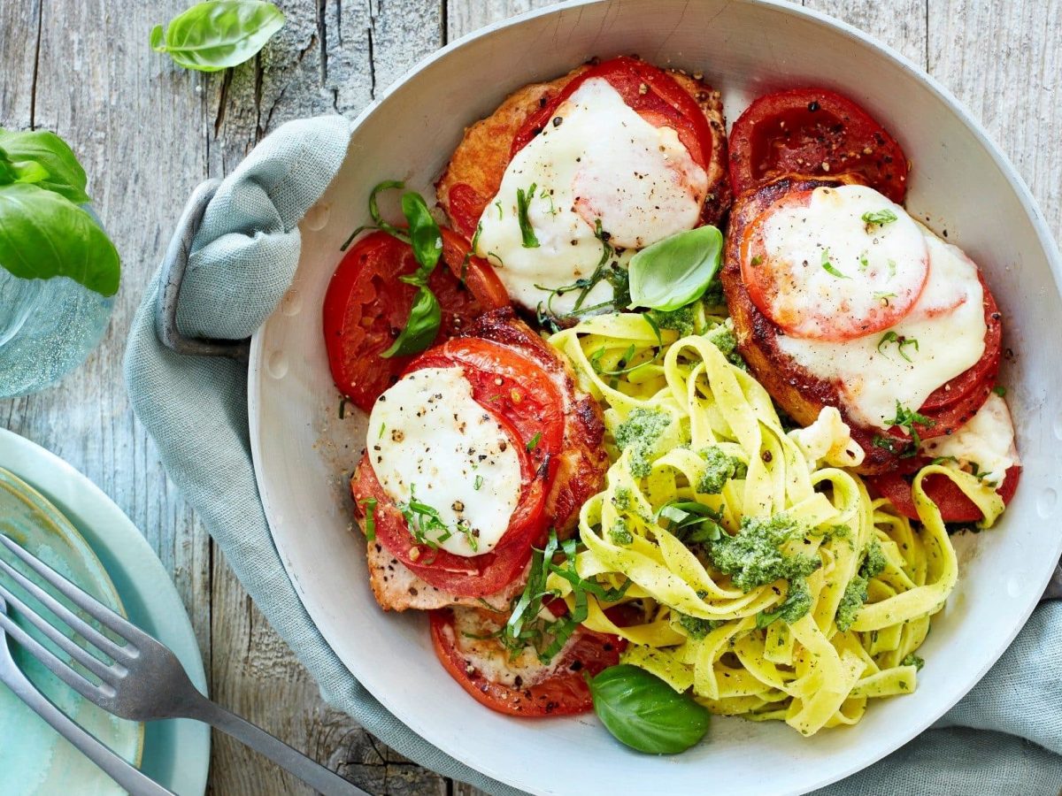 Unsere Minutensteaks Caprese angerichtet mit Bandnudeln in einer Pfanne.