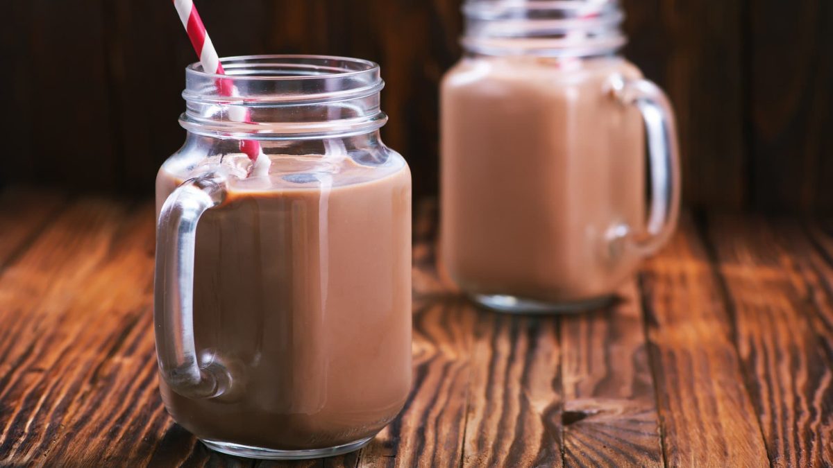 Zwei Gläser mit Nutella-Milch stehen auf einem dunklen Untergrund. In jedem Glas steckt ein Strohhalm.
