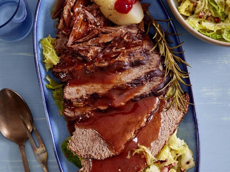 Unser Rinderbraten mit Wirsing steht angerichtet auf einer feinen ovalen Platte auf dem Tisch.