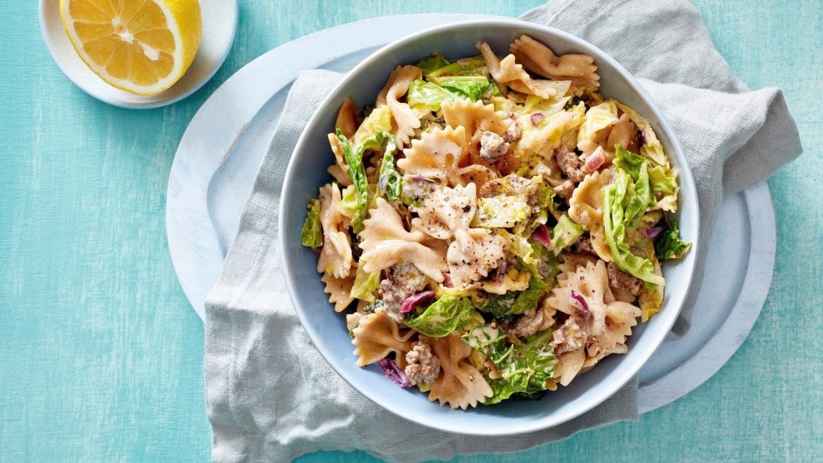 Eine Schüssel voll von unserer Nudelpfanne mit Wirsing und Hackfleisch steht auf dem Tisch.