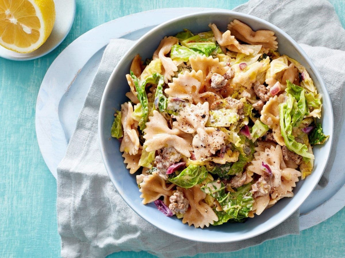 Eine Schüssel voll von unserer Nudelpfanne mit Wirsing und Hackfleisch steht auf dem Tisch.