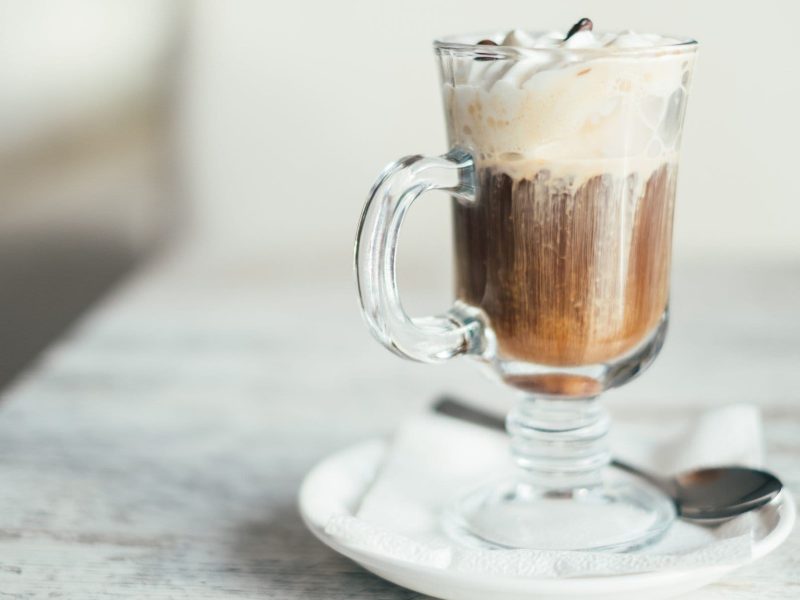 Irish Coffee mit Sahne in gläserner Tasse.