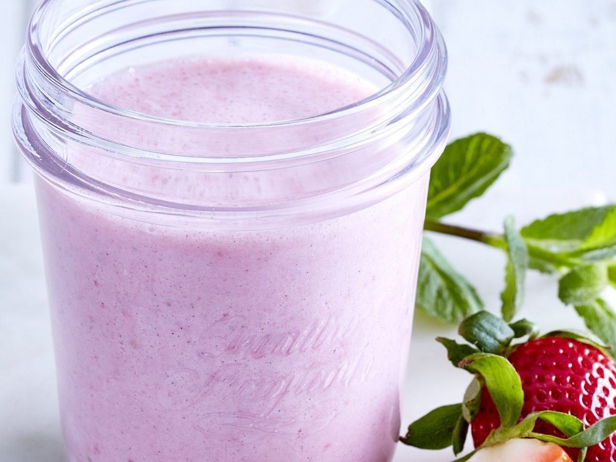 Erdbeer-Kefir-Shake einem Glas neben frischen Erdbeeren