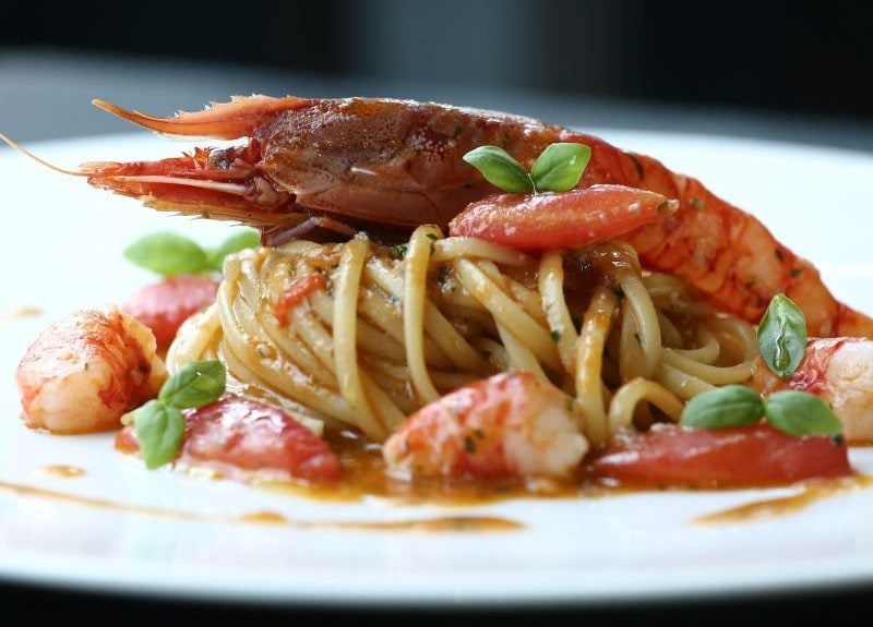 Nahaufnahme eines Tellers mit Tagliatelle, Tomaten und Carabinero.