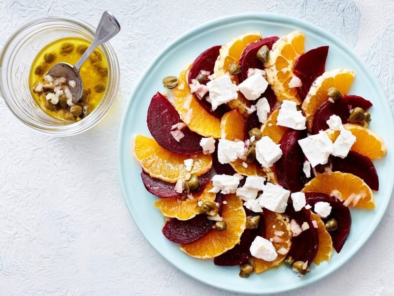 Unser Rote-Bete-Salat mit Orange fein angerichtet auf einem flachen Teller. Dazu ein Kapern-Schalotten-Dressing.