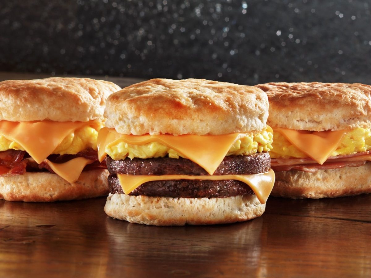 Drei verschiedene Buttermilch Biscuit Burger auf einem hölzernen Untergrund.