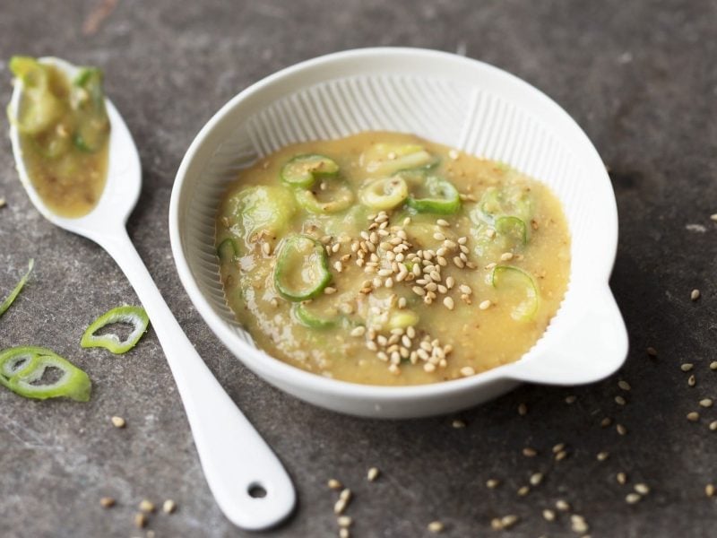 Würziger Miso-Dip mit Frühlingszwiebeln und Sesam und japanischen Gewürzen auf einem steinernen Tisch.